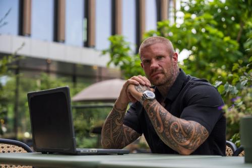 man buiten werkend met laptop